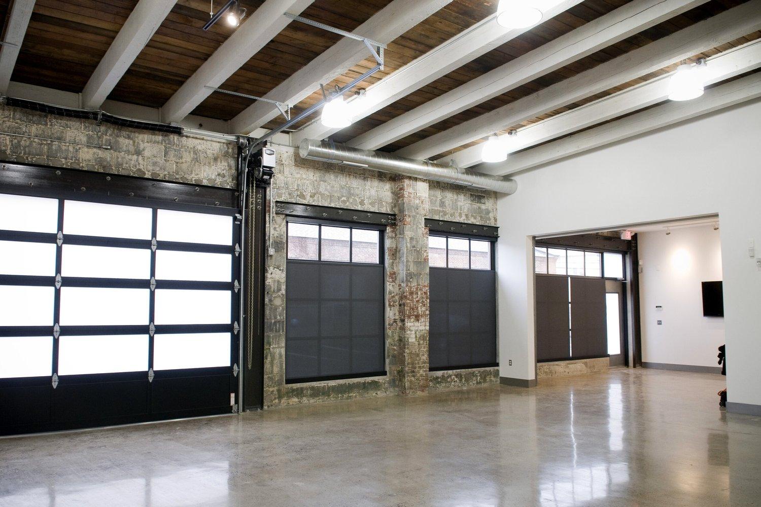 Loft interior at 107 Forest Street with glass garage doors and exposed beams