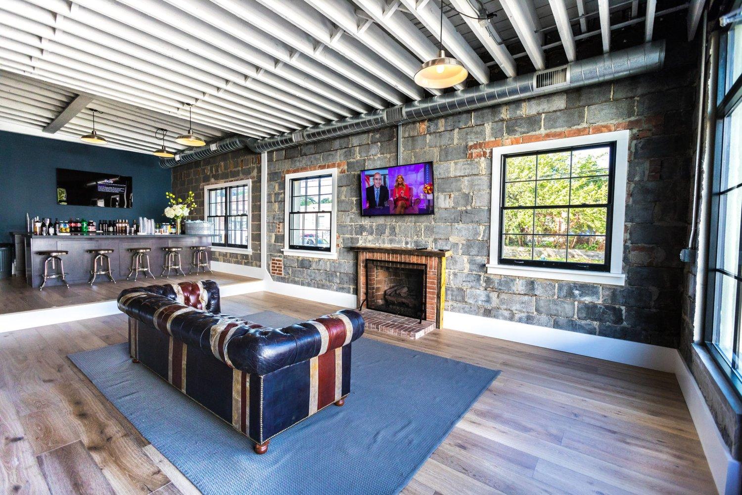 The Annex lounge with exposed joists, stone fireplace and steel windows